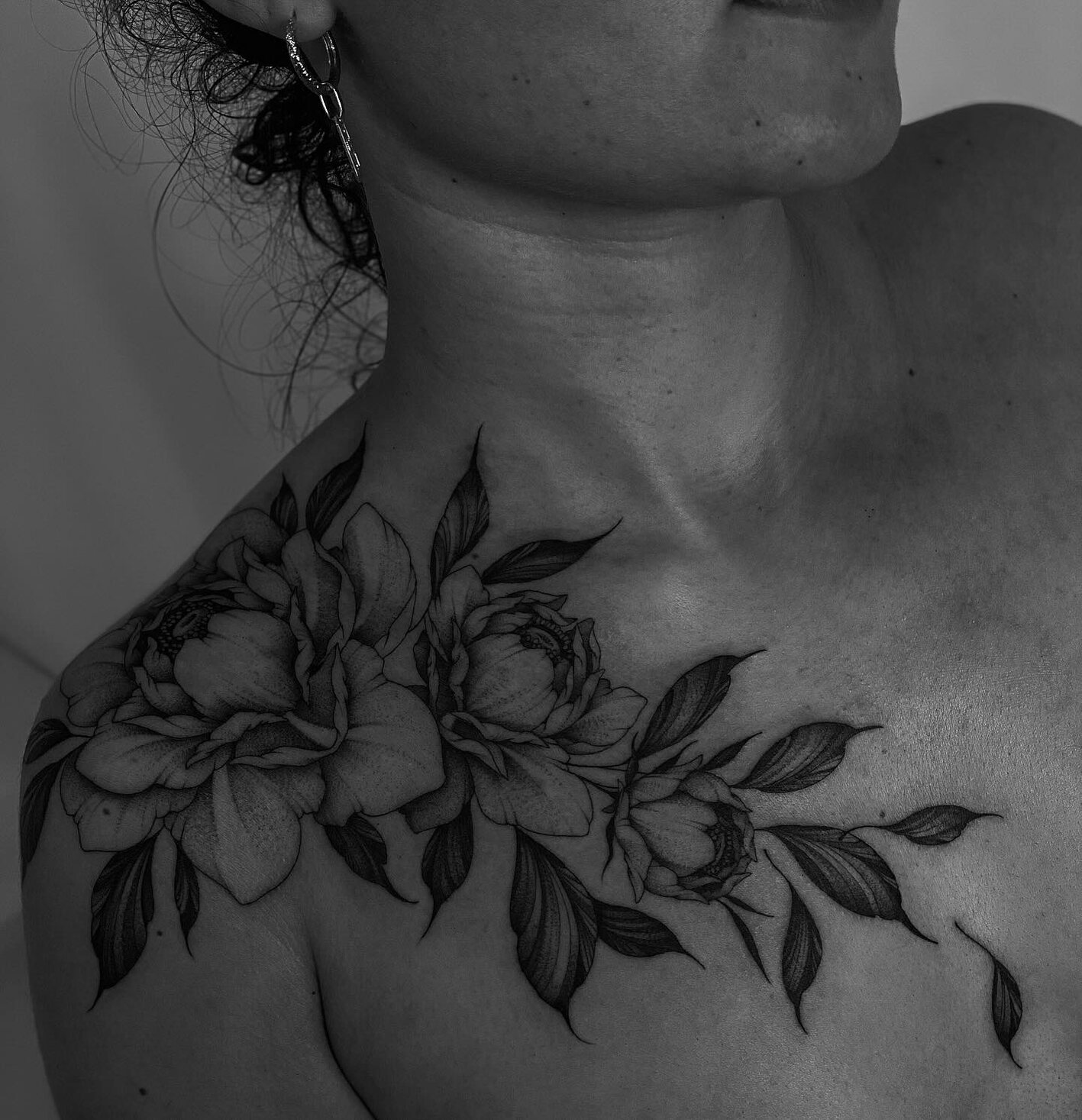 Composition florale fine line sur la clavicule